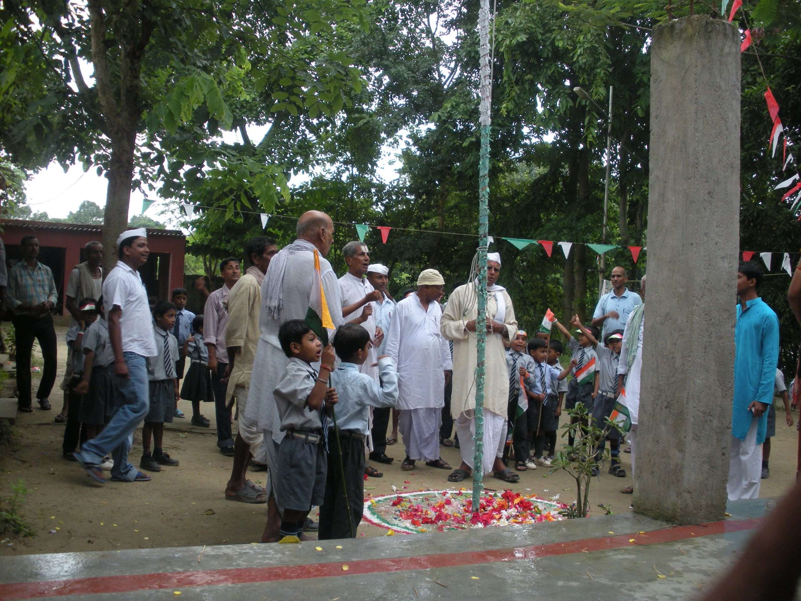 Community flag hoisting ceremony with villagers and tricolor flags