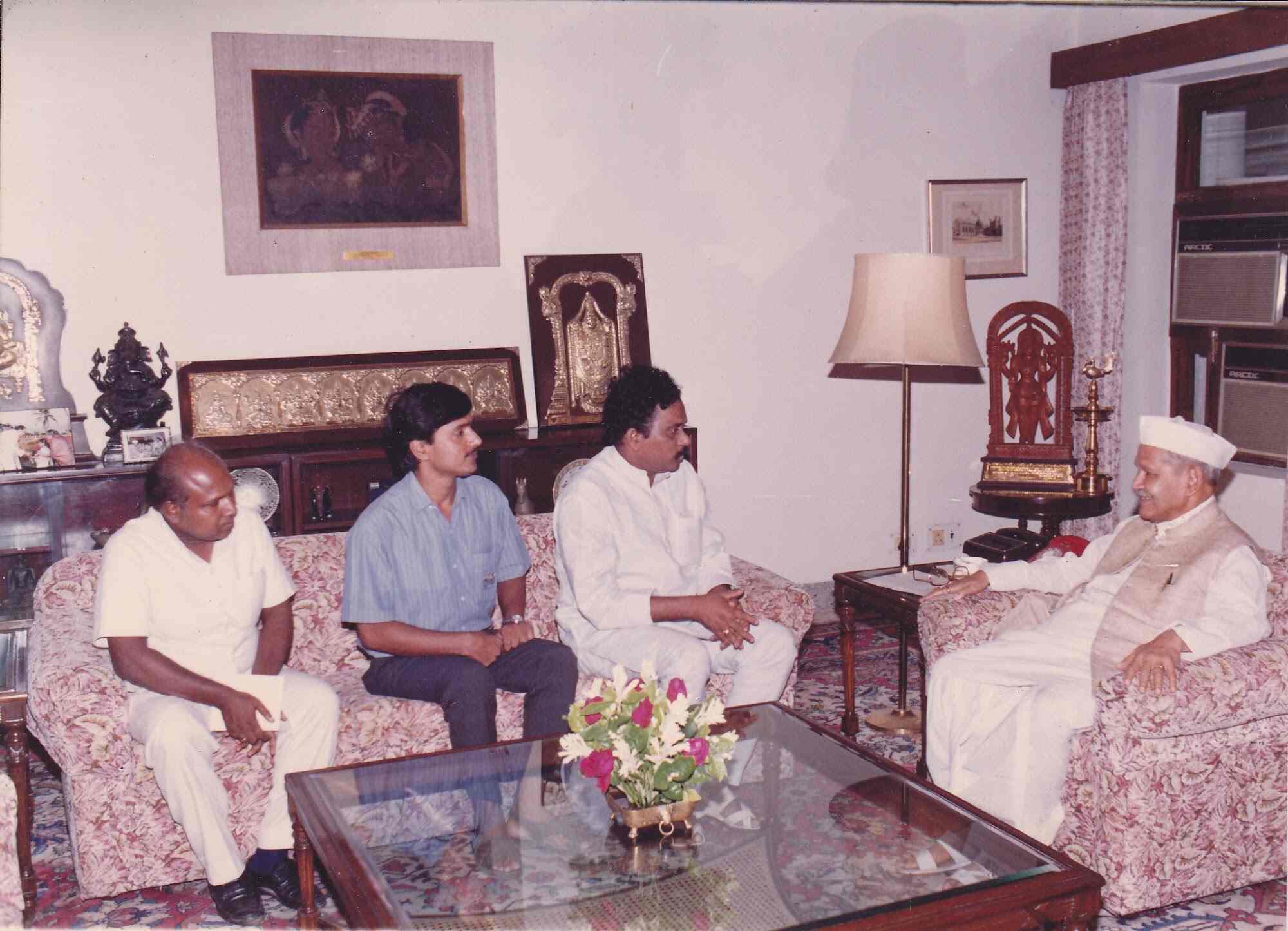 Vintage photograph of three Trust members in conversation with a senior official in his living room