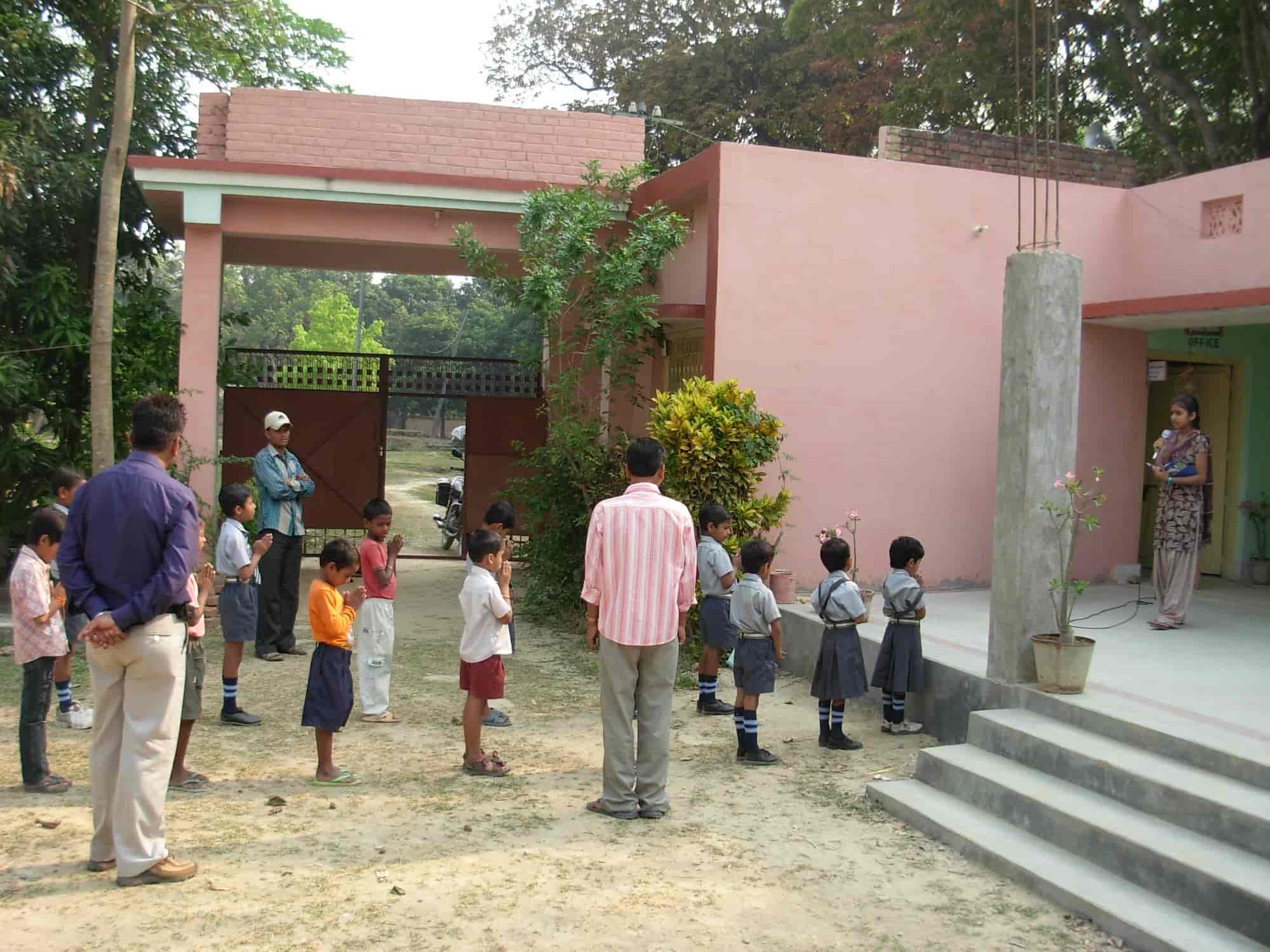 Children at morning prayer assembly outside the Trust school's pink building