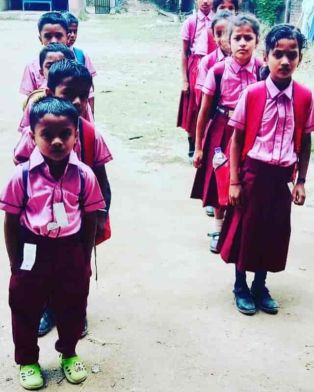 School students in pink uniforms standing in a queue, ready for assembly